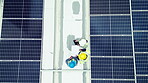 Overhead, solar energy and a maintenance team on the roof of a building to install panel technology. Construction, contractor and renewable electricity with people working on a sustainability project