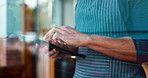 Hands, tablet and a waiter in a coffee shop for an online order as a small business owner or entrepreneur. Technology, ecommerce and retail with a restaurant worker closeup in a startup cafe