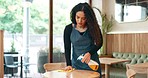 Woman, cafe and cleaning table with spray, cloth and chemical disinfection for hygiene in coffee shop. Restaurant, waitress and wipe wooden furniture surface for bacteria, dirt and safety in store