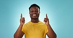 Black man, pointing up and advertising presentation with information or news with ambassador on blue background. Promotion, mockup space and launch announcement with marketing and ads in a studio
