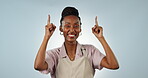 Happy, black woman or pointing in studio to mockup space in apron with smile, offer or cafe choice. Blue background, diner promotion or African waitress advertising business, discount or special deal