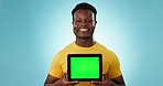 Face, man and green screen space on tablet in studio for advertising, review and sign up on blue background. Happy african model, portrait and presentation of digital marketing, newsletter and launch