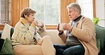 Senior couple, talking and relax in home with coffee, drink or conversation in morning together in retirement. Old people, speaking and drinking tea, espresso or cappuccino on sofa in living room