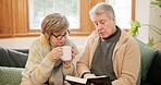 Coffee, bible and senior couple on sofa in home for religion, spiritual learning and faith. Christianity, retirement and elderly man and woman reading holy book for bonding, relax or worship on couch