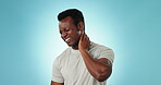 Neck pain, spine injury and black man with massage, sick with fibromyalgia and health fail on blue background. Inflammation, body ache and medical emergency in studio with muscle tension and hurt
