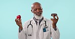 Choice, senior man or doctor with a donut, apple or nutrition with diet plan, healthcare or smile on blue background. African person, model or medical professional with a decision, option or wellness