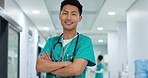 Face, doctor and confident with smile in hospital with arms crossed for leadership in medicine. Asian man, person or nurse in cardiology, emergency care or health for treatment of patient at clinic