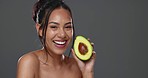 Woman, avocado and beauty in studio for health, diet or smile on face for skincare by background. Girl, model or happy for fruit, nutrition choice or vegan food for wellness, natural glow or portrait