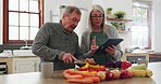 Senior couple in kitchen, cooking with tablet and help with online recipe for vegetable dinner. Healthy food, old man and woman in home checking digital app on meal prep, diet planning and lunch chat