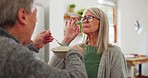 Tasting, senior couple and feeding breakfast, eating and care with help in marriage. Happy, talking and an elderly man  and woman with food, lunch and dinner for nutrition together in a house