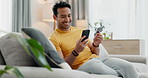 Credit card, phone and man doing online purchase from couch in a home as ecommerce with internet to relax. Happy, website and person buying on the web or banking on app on living room sofa to pay