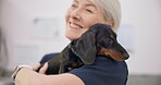 Smile. hug and puppy with an old woman vet in an animal clinic for healthcare or treatment. Pet, love and a happy senior medicine professional stroking a dog while working as a medical veterinarian