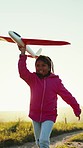 Kid, running and toy in hand on countryside, road and vacation for visit, family or travel in summer. Youth, girl and alone with smile, happy and playing with aeroplane, carefree or fun on holiday