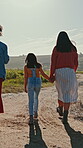 Road, countryside and girls walking on holiday in nature together as bonding on a farm for vacation. Holding hands, siblings and women with child for travel on a field or sustainability landscape