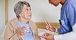 Explain, nurse or senior patient with pills or supplements for healthcare vitamins or medicine in home. Water, medication tablets or caregiver giving drugs for nursing or helping a sick elderly woman