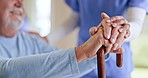 Empathy, walking stick and hands of senior man with caregiver in a nursing home for comfort or support. Trust, help and female nurse touching elderly male with a disability for hope of recovery