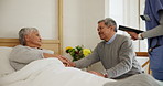 Senior, couple and visit in retirement with nurse for healthcare, wellness and medical check up in bedroom. Elderly, woman and man holding hands for support, trust and empathy in nursing home or love