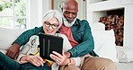 Old couple on sofa with tablet, smile and relax with love, interracial marriage and bonding in home. Social media meme, digital app and happy people, senior man and woman on couch in living room.