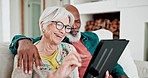 Old couple on couch with tablet, smile and relax with love, interracial marriage and bonding in home. Social media meme, digital app and happy people, senior man and woman on sofa in living room.