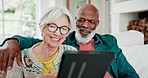 Old couple on couch with tablet, relax and smile with love, interracial marriage and bonding in home. Social media meme, digital app and happy people, senior man and woman on sofa in living room.