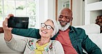 Old couple on sofa with love, smile and selfie for memory, interracial marriage and bonding in home. Social media, mobile app and photography, happy senior man and woman relax on couch in living room