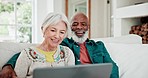 Old couple on sofa with laptop, smile and relax with love, interracial marriage and online bonding in home. Computer, streaming website and happy people, senior man and woman on couch in living room.