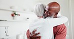 Interracial, happy couple and hug with love and support at home, comfort with empathy or hello with old people. Retirement, life partner with black man and woman in marriage with embrace in kitchen