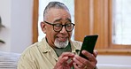 Senior man, phone text and laughing at home with retirement and living room with social media app on sofa. Mobile networking, elderly male person and website with online message in a lounge with meme