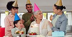 Family, singing and birthday celebration for grandmother, love and senior woman blowing candles on cake. Smiling people, clapping and appreciation or support for elderly person, event and party hats