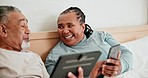 Happy senior couple, phone and tablet in a bed for social media, bonding and sharing funny meme at home. Love, relax and old people in a bedroom with digital, smartphone or app for streaming or gif