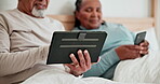 Hands, technology and senior couple in bed, typing and talking together in the morning. Tablet, happy man and woman on phone closeup in bedroom on internet, social media and online shopping at home