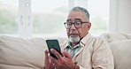 Relax, email and a senior man with a phone on the home sofa for communication and social media. Technology, scrolling and an elderly person reading news on a mobile app or the internet online