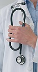 Closeup hand, doctor or stethoscope for healthcare, hospital work or service in cardiology. Standing, health and a medical employee or surgeon with clinic equipment for a checkup with experience