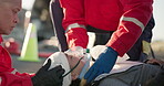 Hands, medical and emergency with an emt team on the scene of an accident to rescue a person. Healthcare, medicine and paramedic services with a group of people in uniform helping an injured victim