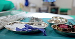 Surgery tools, equipment and metal on table in hospital, operation theatre or clinic. Desk, medical instruments and surgical scalpel, sterile steel bowl or clean ppe for healthcare in emergency room