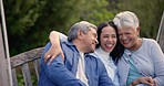 Happiness, park and senior parents with woman in nature and hug on holiday or vacation for bonding together with love. Laughing, outdoor and elderly people pointing or embrace on bench with daughter