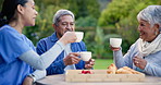 Cheers, nurse and a couple with coffee in a garden for conversation, care and relax in the morning. Happy, toast and a female caregiver speaking to a senior man and woman during breakfast in nature