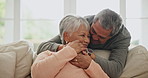 Old couple, couch and hug with love and support in marriage, retirement and happiness together at home. Comfort, care and bonding with life partner, people in living room with trust and commitment 