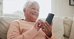 Senior woman, smartphone and social media on living room couch, memes or technology. Retired, happy or enjoying retirement to relax, mobile app or texting for social network, streaming and connection