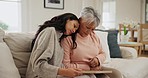 Sad, woman and senior mother with support in home for mourning, grief or depressed with memory. Elderly, mom and crying on shoulder of person in living room with photograph, frame and loss to cancer