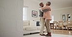 Senior, couple and hug with dance in living room of home for bonding, romance and happiness or love. Elderly, man and woman holding hands together or dancing in lounge of house for celebration or joy