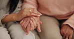 Hands, senior and women with empathy or support for retirement, compassion or trust on sofa of home. Elderly, people and hand holding for care, kindness and sympathy in hospice or comfort on couch