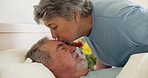 Sick, kiss and elderly couple in bed at hospital for rehabilitation, healing or recovery from cancer surgery. Love, senior man and woman at clinic to visit person sleeping to care, empathy or support