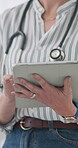 Tablet, hands typing and doctor research, telehealth and online healthcare in hospital. Tech, medical worker and woman closeup on digital app, writing email and scroll website or internet in clinic