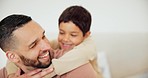 Father, child and hugging for love in home for development, bond or caring. Man, boy and smile on face in happiness for quality time together on holiday, trip or vacation in living room to play game