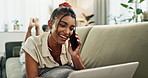 Laptop, phone call and funny woman on sofa in home, talk and communication. Computer, smartphone and happy Indian person laughing on couch in living room, conversation or comedy, joke or mobile meme
