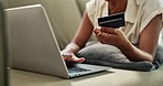 Closeup, hand and laptop with credit card for payment by typing on website for online shopping. Female, consumer and fintech for e commerce, digital banking or electronic purchase from home on sofa