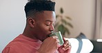 Man, drink and coffee for peace in home to relax, alone and wellness for quality time. African person, enjoy and delicious beverage on break from work for thinking, day dream or rest in living room

