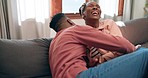 Man, woman and silly on sofa in home with laugh, smile and joy for playing in living room for fun. African people, married and relax with spouse with love in relationship for bond, trust and care 