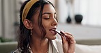 Woman on sofa eating chocolate bar with smile, taste and relax with candy in living room. Happiness, sweets and girl on couch with sugar snack, dessert and enjoy in home with comfort food for lunch.